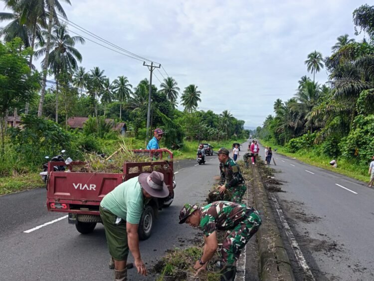 Wujud Nyata Pengabdian TNI, Koramil 04/Dimembe Gotong-Royong Bersama Masyarakat Bersihkan Jalan Utama