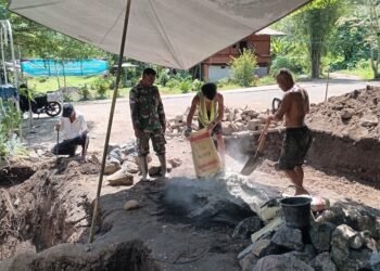 Percepat Progres Pembangunan, Babinsa Koramil 1310-06/Airmadidi Bantu Pemasangan Pondasi Dudukan Angker Jembatan Perintis Garuda di Kelurahan Rap-Rap
